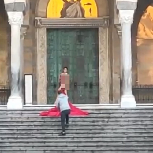 Shooting sulla scalinata del Duomo di Amalfi: modella posa coperta solo da un velo rosso / FOTO-VIDEO
